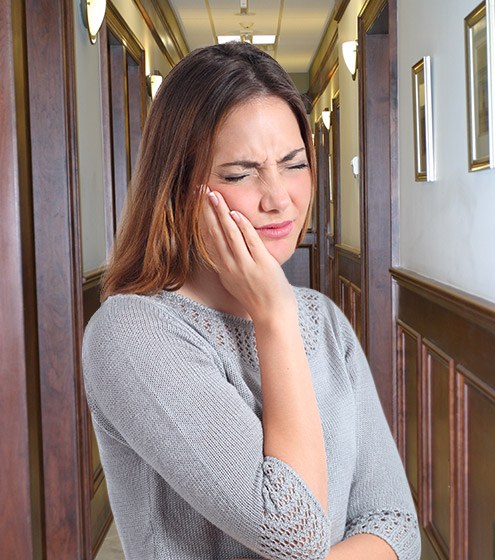 Woman holding cheek in pain