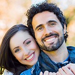 Smiling man and woman outdoors