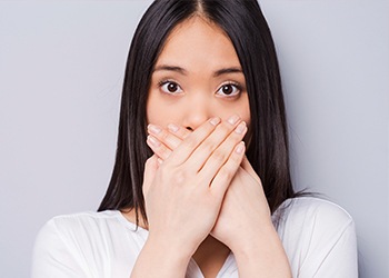 Woman hiding her smile with her hands