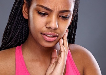 Woman holding jaw in pain